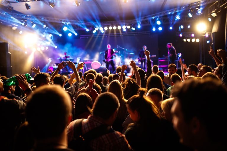 Crowd of young people with hands up on concert